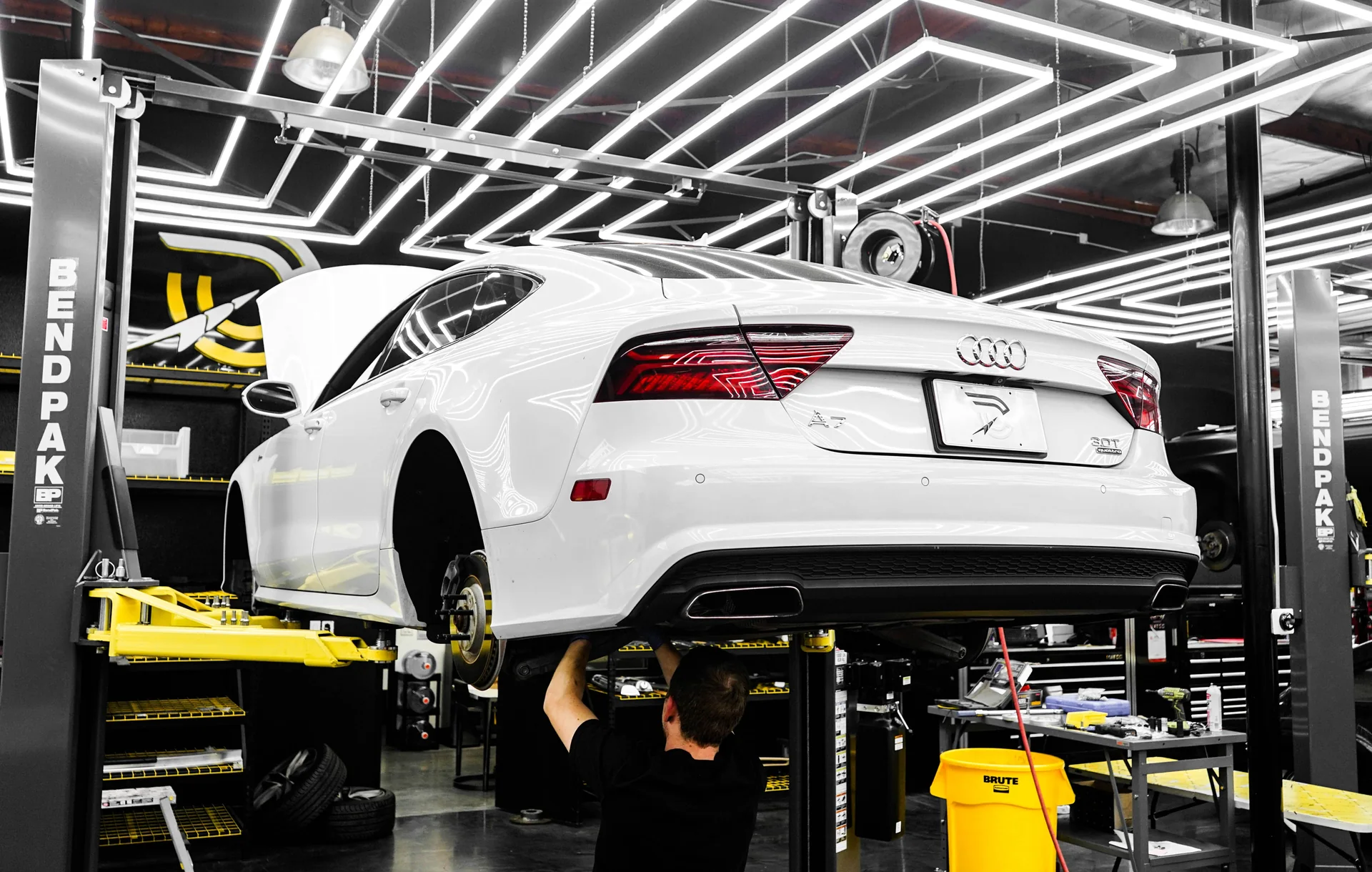 リフトに上げられた車を整備している工場
